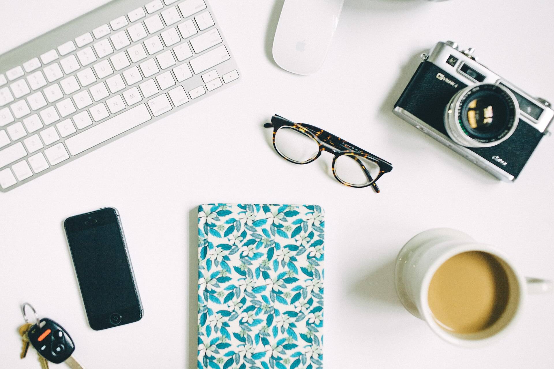 Notebook, keys, and coffee on a desk
